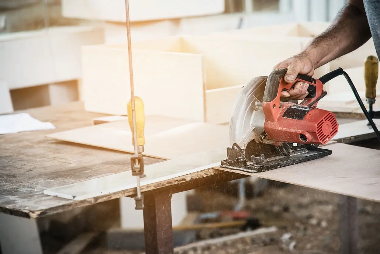 Menuisier découpant une planche en bois sur mesure