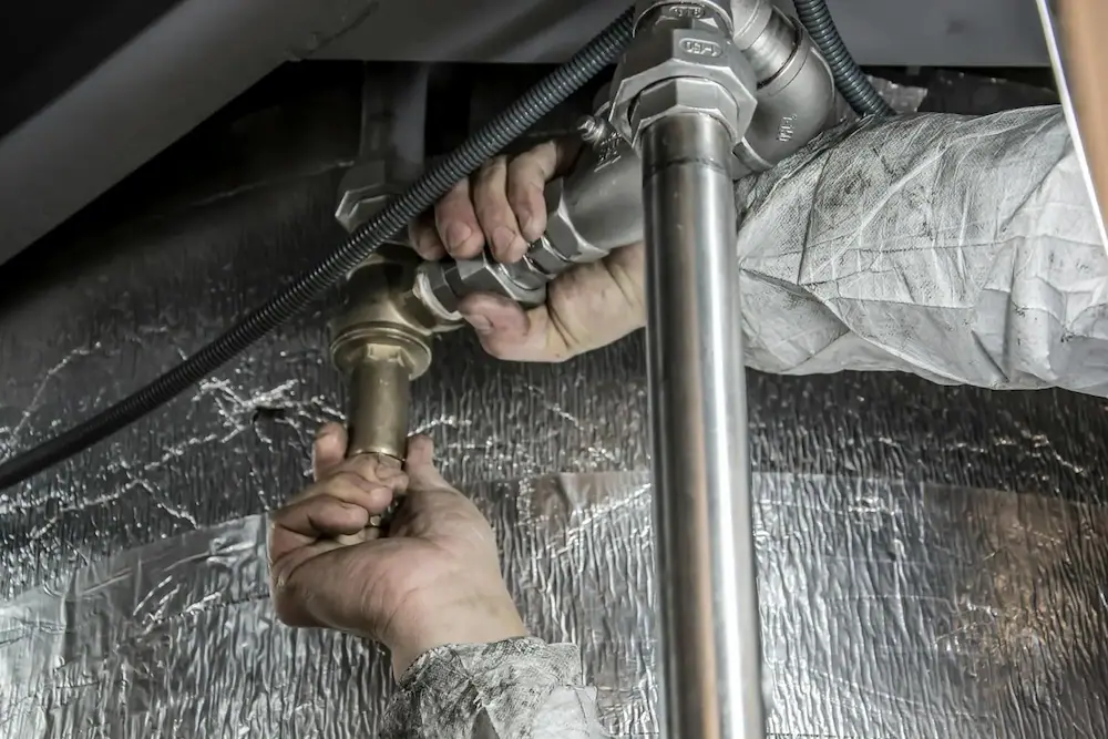 Plombier effectuant une réparation de canalisation